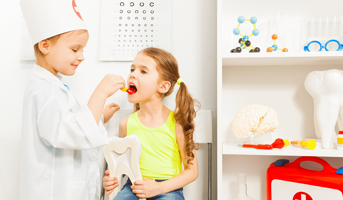 A child role-playing as a dentist with a friend at the office
